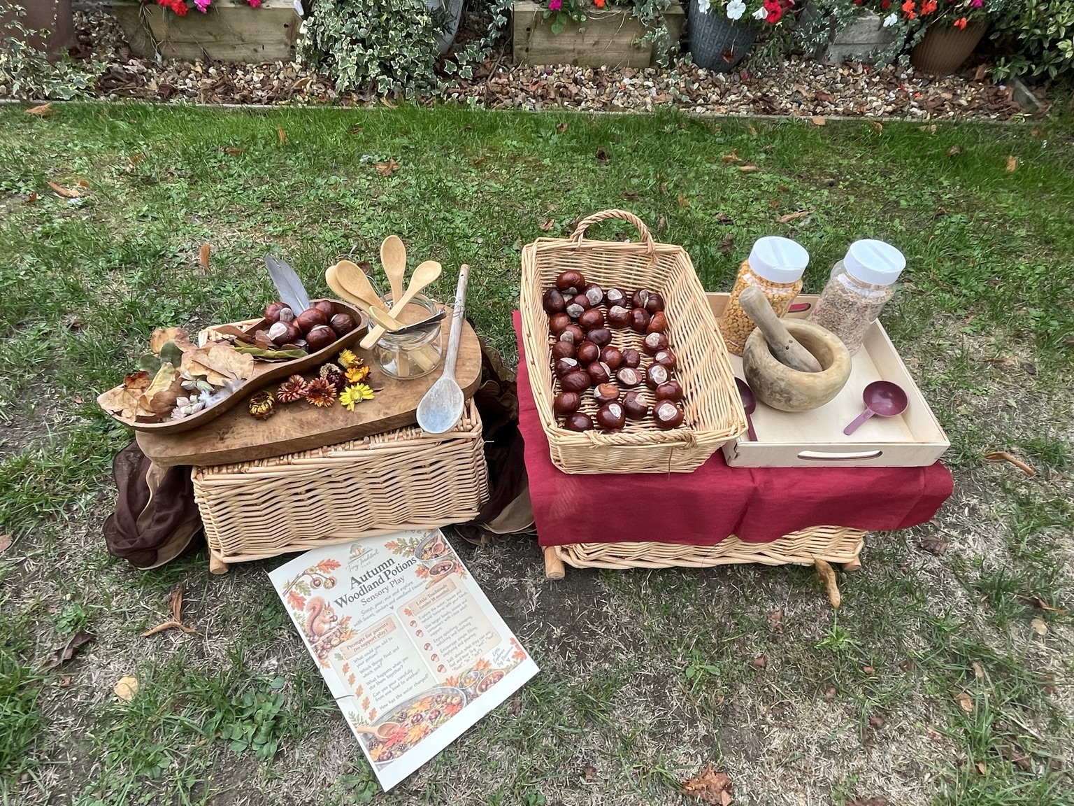Autumn potion invitation with wicker baskets, conkers, fallen leaves, spoons and a wooden mortar